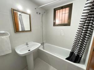 y baño blanco con lavabo y bañera. en Apartamentos Bernat 3000, en Oropesa del Mar