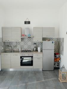 eine Küche mit Küchengeräten aus Edelstahl und weißen Schränken in der Unterkunft Incantevole appartamento tra Portofino e le 5 Terre in Chiavari