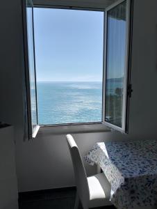 a table and a chair in a room with a large window at Incantevole appartamento tra Portofino e le 5 Terre in Chiavari