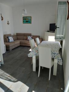 ein Wohnzimmer mit einem Tisch, Stühlen und einem Sofa in der Unterkunft Incantevole appartamento tra Portofino e le 5 Terre in Chiavari