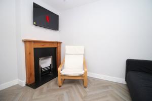 a white chair sitting in front of a fireplace at Cohost Partners, Monthly/Weekly discounts in Bristol