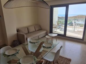 a living room with a table and chairs and a couch at Luxury Penthouse Golf, sea view in Pilar de Jaravía