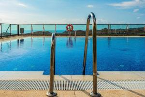 a swimming pool with blue water and two metal bars at Luxury Penthouse Golf, sea view in Pilar de Jaravía