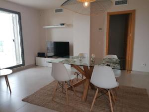 a dining room with a glass table and white chairs at Luxury Penthouse Golf, sea view in Pilar de Jaravía