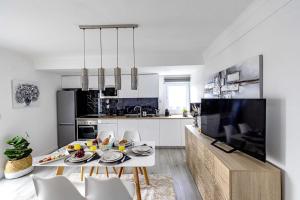 a white kitchen with a table and some chairs at Vista MarVilla Eira Nova in Porto Covo