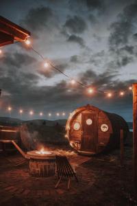 a room with a barrel and a table and lights at Drvena bačva za spavanje in Posušje