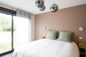 a bedroom with a white bed and a large window at Le Petit Rocher in Vienne