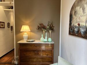 a room with a dresser with a lamp and vases on it at Villa Liberty TownHouse in Siena