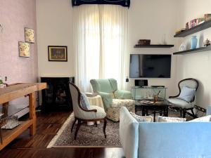 ein Wohnzimmer mit einem Sofa und Stühlen in der Unterkunft Villa Liberty TownHouse in Siena