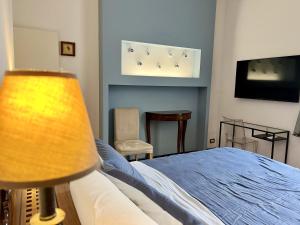 Schlafzimmer mit einem Bett und einem Flachbild-TV in der Unterkunft Villa Liberty TownHouse in Siena