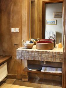 a bathroom with a counter with a sink and a mirror at Lousiou Nymphes escape suites in Dhimitsana
