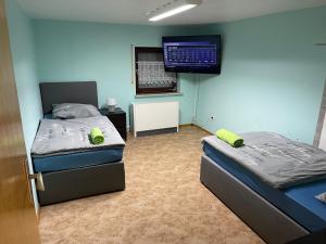 a room with two beds and a flat screen tv at Chambre avec 2 lits in Trier