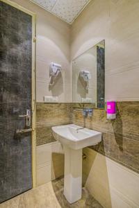 La salle de bains est pourvue d'un lavabo et d'un miroir. dans l'établissement Hotel Smart Plaza Delhi Airport, à New Delhi