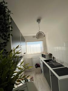 a small kitchen with a stove and a microwave at Logement entier : appartement proche de Paris ⸱ Chez Geoffrey in Châtillon