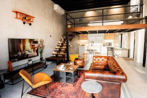 a living room with a brown leather couch and chairs at NSMA - The Loft experience in Riyadh