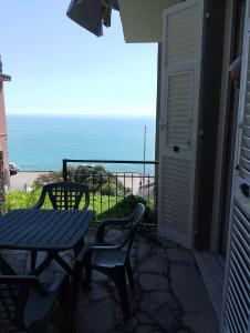 eine Terrasse mit einem Tisch, Stühlen und Meerblick in der Unterkunft Incantevole appartamento tra Portofino e le 5 Terre in Chiavari