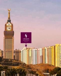 SAJA Hotels Makkah في Al Masfalah: برج ساعه طويل مع ساعه فوق مبنى