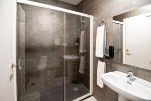 un baño con ducha y lavabo en Hotel Manzanito, en Antequera
