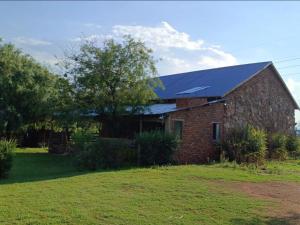 una casa de ladrillo con techo azul en Crooked Cottage, en Pelindaba
