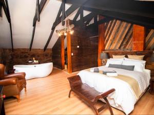 Un dormitorio con una cama grande y una bañera. en Crooked Cottage, en Pelindaba