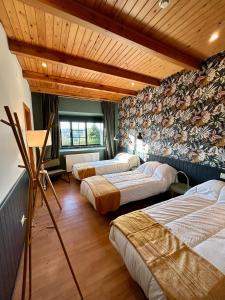 um quarto com 4 camas num quarto com tectos em madeira em Casa Bolboreta em Palas de Rei