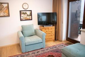 a living room with a chair and a tv at Tal Blick 3-Zimmer Nordenau/ Winterberg in Schmallenberg