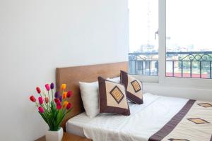 ein Schlafzimmer mit einem Bett mit einer Blumenvase in der Unterkunft Sumitomo 6 Apartment _ No 12 lane 523 Kim Ma street in Hanoi