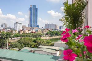 un balcone con fiori rosa e vista sulla città di Sumitomo 6 Apartment _ No 12 lane 523 Kim Ma street a Hanoi