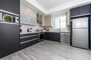 a kitchen with black cabinets and stainless steel appliances at Green Bay Villa #15 in Protaras