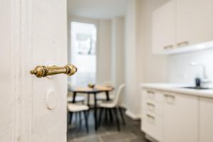 a doorhandle to a kitchen with a table at Schiller Apartment Neukölln in Berlin