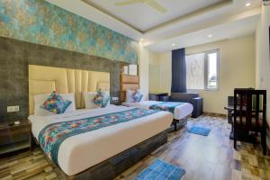 a hotel room with two beds and a desk at Hotel Smart Plaza Delhi Airport in New Delhi