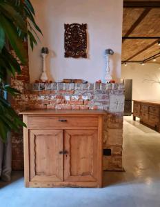 cocina con pared de ladrillo y armario de madera en Vakantiewoning in monumentale boerderij met yurt, en Eckelrade