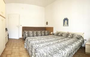une chambre avec un lit avec une couette noire et blanche dans l'établissement Appartamento SARA a Marina di Cecina by Zoom In Earth, à Marina di Cecina