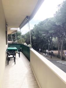 d'un balcon avec une table et une table verte. dans l'établissement Appartamento SARA a Marina di Cecina, à Marina di Cecina