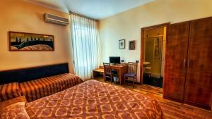 a hotel room with a bed and a desk with a computer at Hotel Nazionale in Bolsena