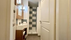 a small bathroom with a sink and a door at Chez Nannou et Chris in Fort-Mahon-Plage +14 photos
