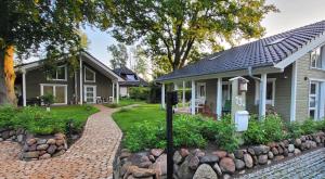 a home with a brick walkway next to a house at Haus Swanhild in Fockbek