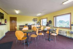 ein Zimmer mit Tischen und Stühlen sowie einer Küche in der Unterkunft Rodeway Inn in Sardis