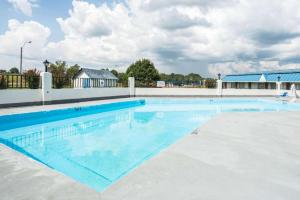 een groot zwembad met blauw water bij Rodeway Inn in Sardis