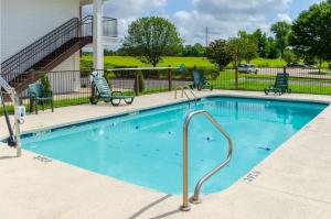 uma piscina com água azul e cadeiras e uma casa em Quality Inn em Vicksburg