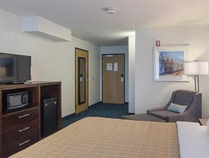 pokój hotelowy z łóżkiem, telewizorem i krzesłem w obiekcie Quality Inn w mieście Seaside