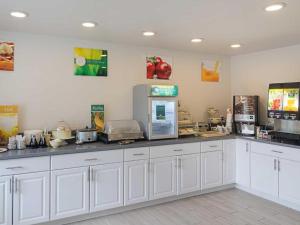 錫賽德的住宿－Quality Inn，厨房配有白色橱柜和柜台。