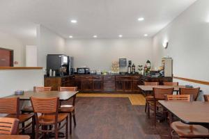 ein Restaurant mit Tischen und Stühlen und eine Küche in der Unterkunft Quality Inn in Bemidji