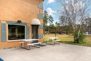 three picnic tables and benches outside of a building at Quality Inn in Bemidji