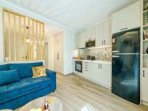un soggiorno con un divano blu e una cucina di Soma Lux Apartment! a Città di Corfù Altre 35 foto