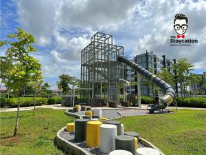 un parc avec toboggan en face d'un bâtiment dans l'établissement Staycation Homestay 41 Liberty Grove Near Airport, à Kuching