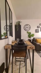 a room with a table with a chair and a clock at Emplacement exceptionnel et rare Paris Suresnes longchamp in Suresnes