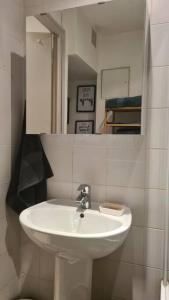 y baño con lavabo blanco y espejo. en Emplacement exceptionnel et rare Paris Suresnes longchamp, en Suresnes