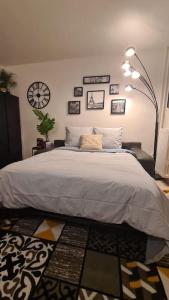 1 dormitorio con 1 cama grande y reloj en la pared en Emplacement exceptionnel et rare Paris Suresnes longchamp, en Suresnes