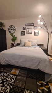 a bedroom with a large bed and a clock on the wall at Emplacement exceptionnel et rare Paris Suresnes longchamp in Suresnes